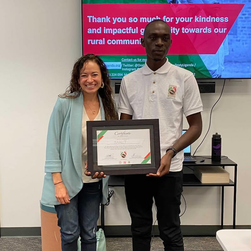 Timothy Ssessaazi, DROTY co-founder, presents SAALT with a Certificate of Appreciation at the SAALT office in Boise, Idaho, 2021.