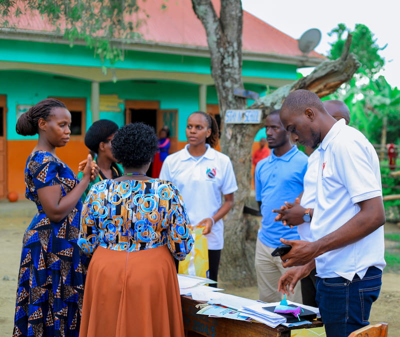 Team members gathered around an outdoor table covered with papers, planning a session together.